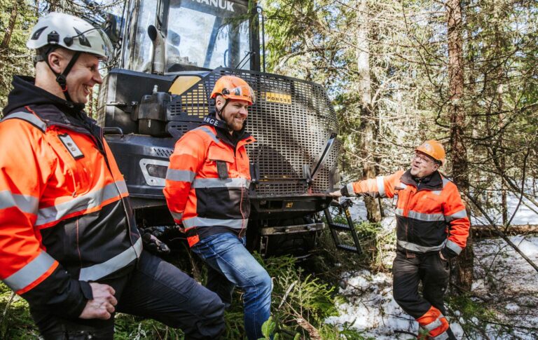 Kai Laaja, Aki Laaja ja metsäkoneen kuljettaja Marko Koppelomäki keskustelevat metsähakkuualueella metsäkoneen vieressä.