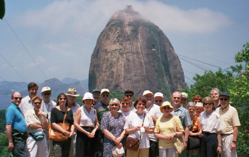 Joukko ihmisiä kokoontuneena Brasiliassa Rio de Janeirossa Sokeritoppavuori taustalla.