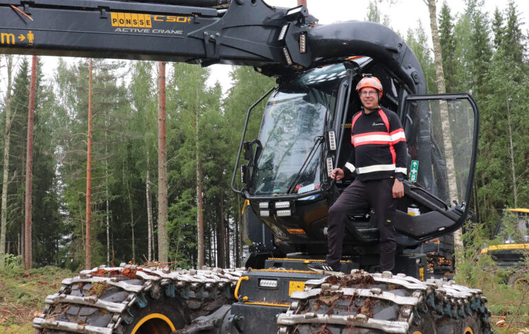 Marko Hauta-Aho poseeraa traktorin vieressä.