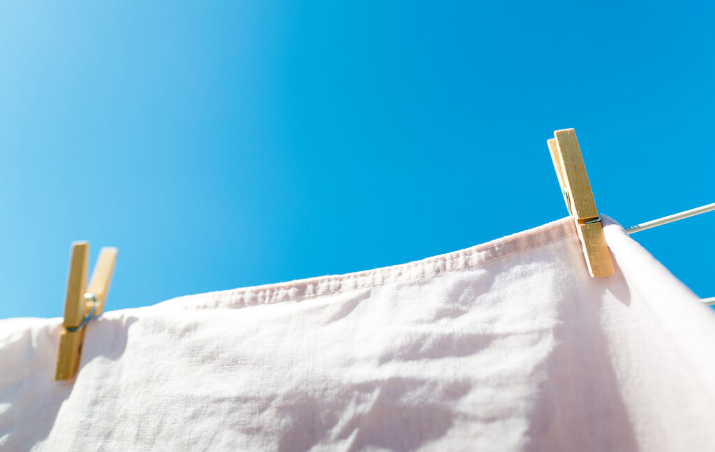 Lakana roikkuu pyykkinarussa ja taustalla on sininen taivas