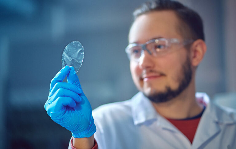 Matias Lakovaara pitää kädessään nanosellukalvoa laboratoriossa