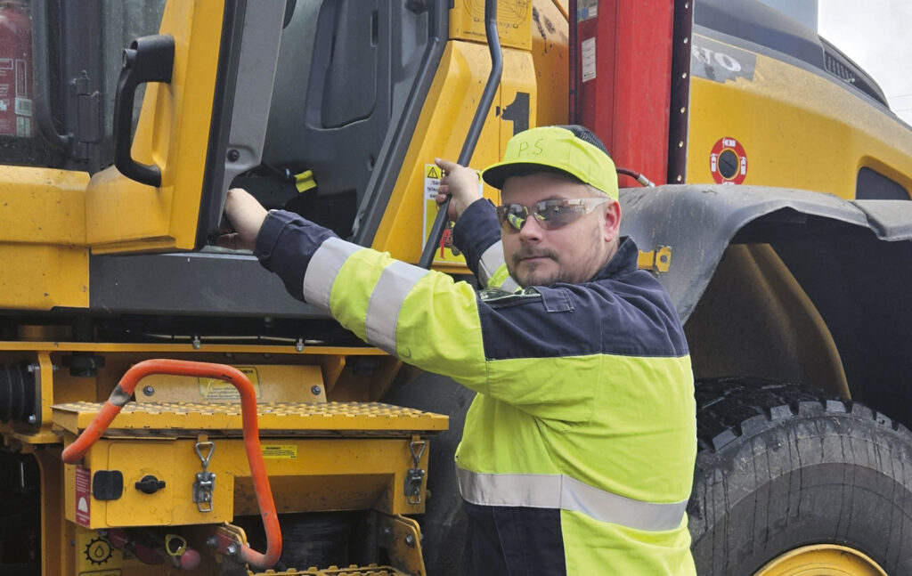 Pertti Salminen poseeraa traktorin edessä