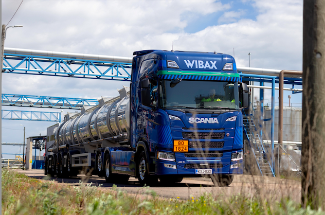 Sininen Wibax-merkitty Scania-säiliöauto kuljettamassa kemikaaleja teollisuusympäristössä