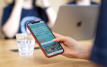 Henkilö selailee kännykällä nettisivuja.