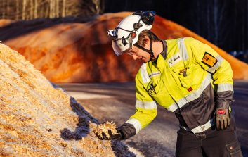 Manu Kalliokoski tutkii puuhakepohjaista raaka-ainetta teollisuusalueella.